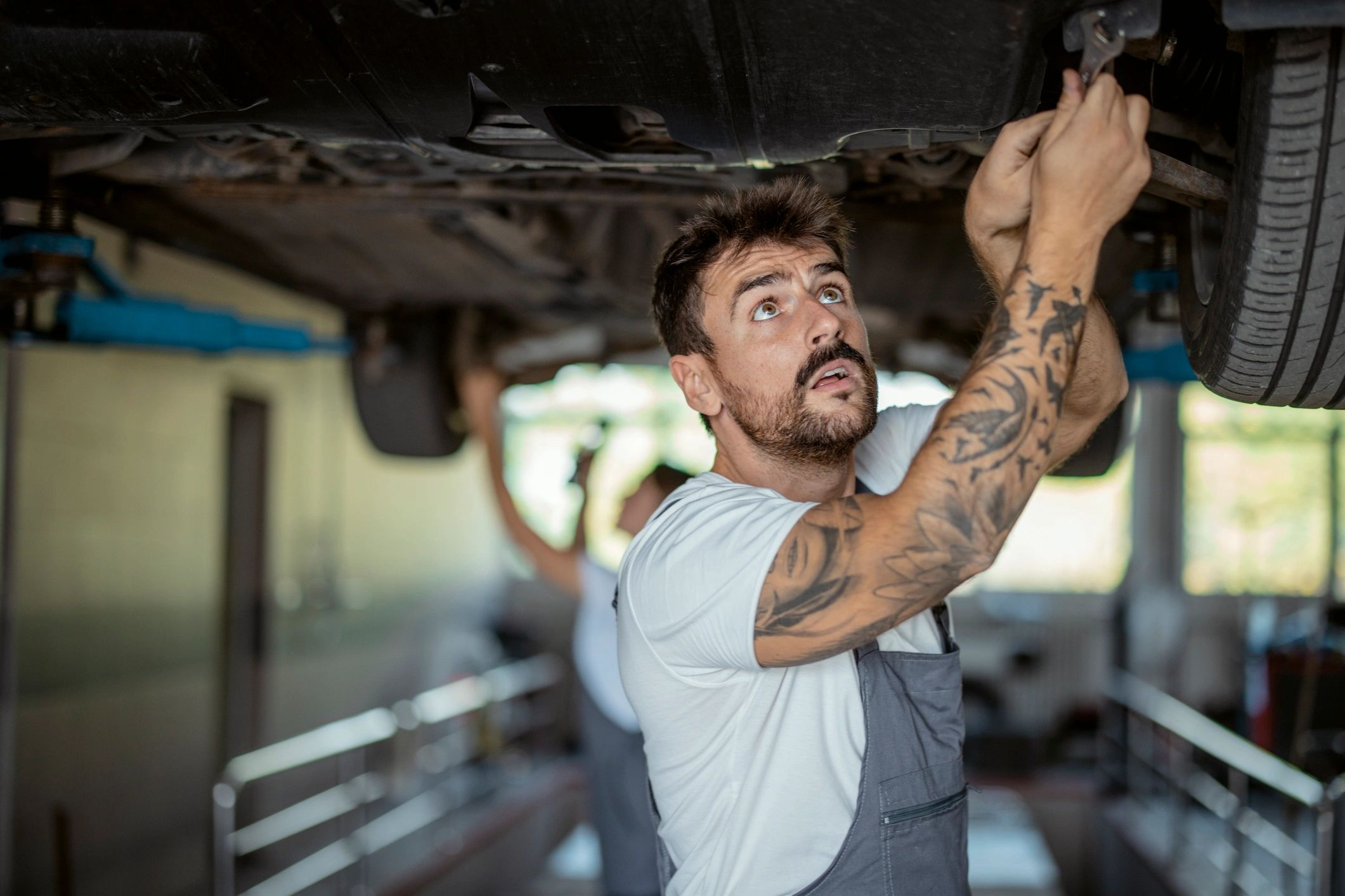 Mechanic servicing a car on a lift